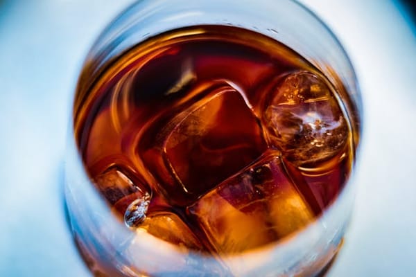 A glass of whiskey on the rocks.